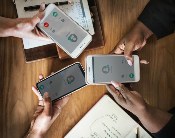 three hands holding phone workplace | The Best Time-Management Apps for Better Work-Life Balance https://positiveroutines.com/best-time-management-apps/ 