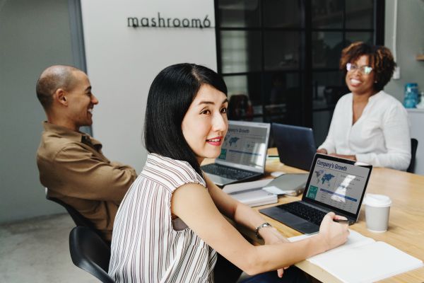 three people working at a desk | 5 Productivity Hacks for Ultimate Email Efficiency https://positiveroutines.com/productivity-hacks-email/ ‎