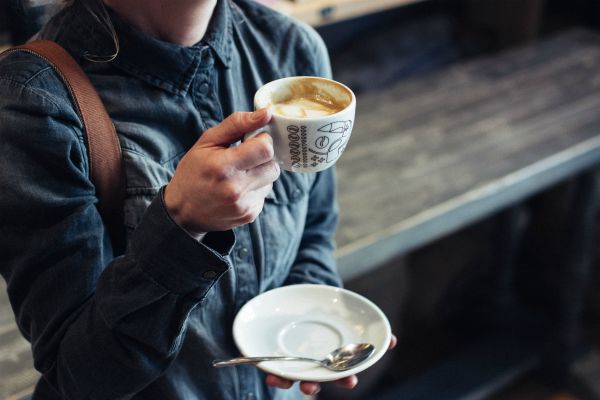 woman drinking cup of coffee standing up | Can Caffeine Help You Do Something Productive? https://positiveroutines.com/do-something-productive/