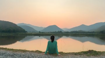 woman looking peaceful at mountains | Why You Need to Try Loving-Kindness Meditation https://positiveroutines.com/loving-kindness-meditation/