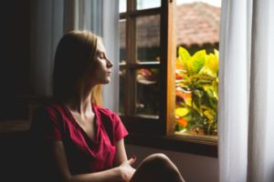 woman sitting eyes closed staring out window | Why You Need to Try Loving-Kindness Meditation https://positiveroutines.com/loving-kindness-meditation/