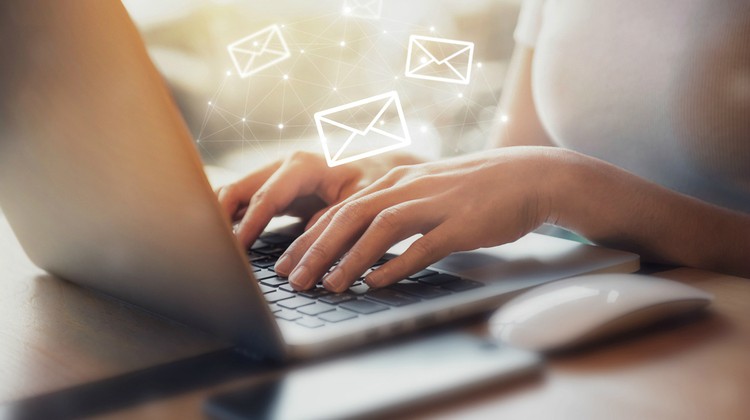 woman typing on laptop with email symbols | 5 Productivity Hacks for Ultimate Email Efficiency https://positiveroutines.com/productivity-hacks-email/ ‎
