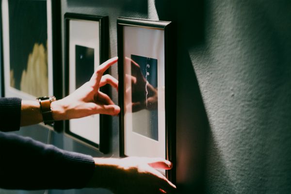 hands shifting a frame on wall | How to Make Being a Perfectionist Work For You  https://positiveroutines.com/being-a-perfectionist/