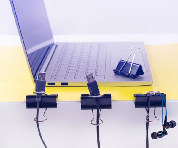 laptop with clips to organize cables | The Best Decluttering Tips for a Productive Workspace https://positiveroutines.com/decluttering-tips/