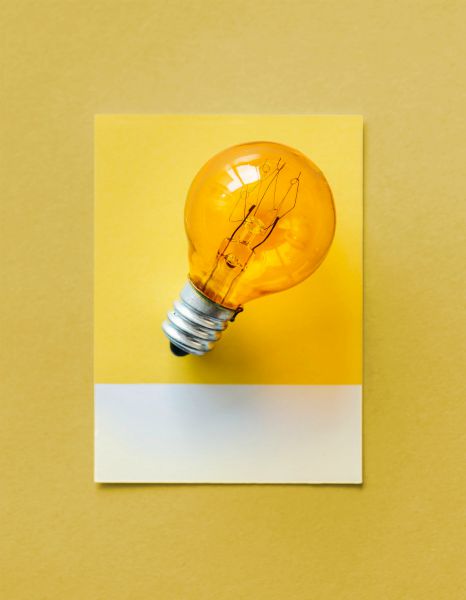 lightbulb on yellow background | How to Make Being a Perfectionist Work For You  https://positiveroutines.com/being-a-perfectionist/