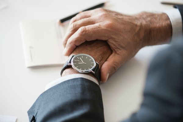 man checking time on watch | How to Make Being a Perfectionist Work For You  https://positiveroutines.com/being-a-perfectionist/