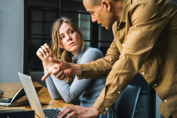 man explaining something to female coworker | Yes, You Can Stop Procrastinating. Here's How. https://positiveroutines.com/stop-procrastinating/