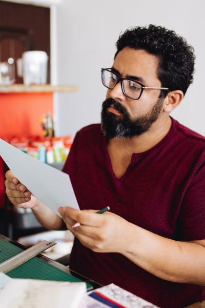man looking intently at paper working | How to Make Being a Perfectionist Work For You  https://positiveroutines.com/being-a-perfectionist/
