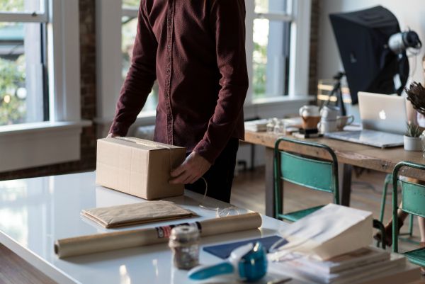 man packing up box in office | The Best Decluttering Tips for a Productive Workspace https://positiveroutines.com/decluttering-tips/