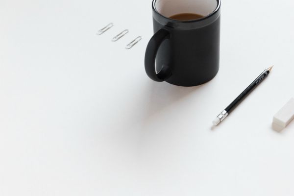 pencil eraser paperclips next to coffee | The Best Decluttering Tips for a Productive Workspace https://positiveroutines.com/decluttering-tips/
