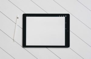 tablet with blank screen on white table minimalist | Yes, You Can Stop Procrastinating. Here's How. https://positiveroutines.com/stop-procrastinating/