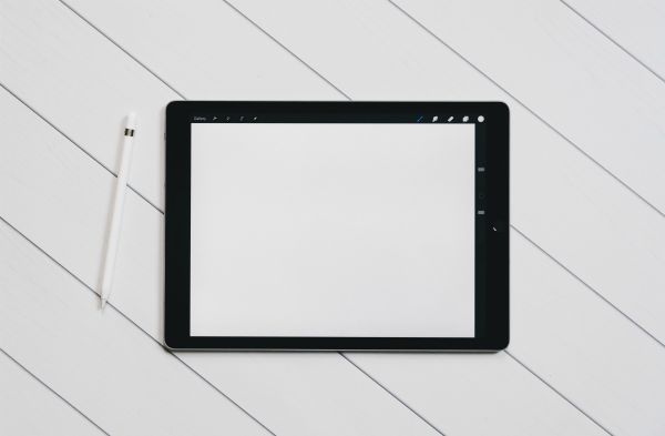 tablet with blank screen on white table minimalist | Yes, You Can Stop Procrastinating. Here's How. https://positiveroutines.com/stop-procrastinating/