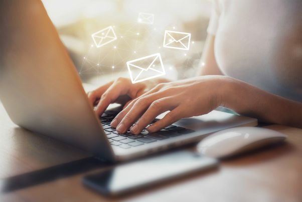 typing on laptop with email icons | 59 Work Tips to Be Better At Your Job  https://positiveroutines.com/best-work-tips/