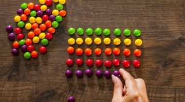 woman organizing candies into perfect rows perfectionism concept | How to Make Being a Perfectionist Work For You  https://positiveroutines.com/being-a-perfectionist/