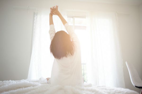 back of woman stretching at morning | Feeling stressed out? 46 Ways to Take Control Now https://positiveroutines.com/tips-for-feeling-stressed/