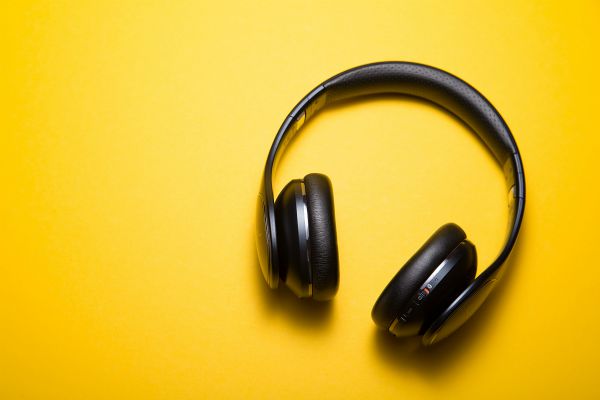 black headphones on yellow background | Can You Use Music For Productivity Gains? https://positiveroutines.com/music-for-productivity/