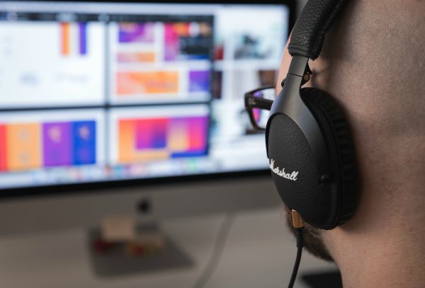 man wearing marshall headphones looking at computer screen | Can You Use Music For Productivity Gains? https://positiveroutines.com/music-for-productivity/