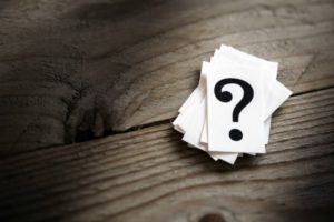 pile of question mark cards on wooden table | How to Handle Job Burnout, Even If You Love Your Work https://positiveroutines.com/job-burnout-guide/