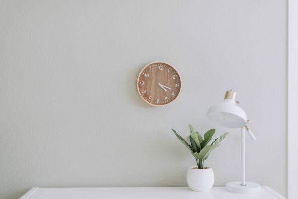 wooden clock over white desk on white wall | How to Use Single-Tasking To Skyrocket Your Productivity  https://positiveroutines.com/single-tasking-productivity/