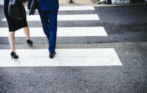 business man and woman crossing pedestrian lane | In Time for the Holidays: How to Take Breaks Effectively  https://positiveroutines.com/how-to-take-breaks/