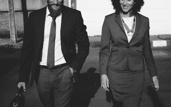 grayscale of man standing beside woman holding handbag | How to Make the Most of Your Commute to Work https://positiveroutines.com/commute-to-work-tips/