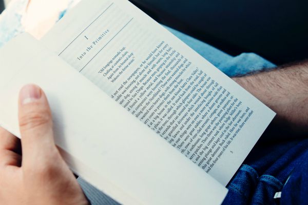 man reading book | How to Make the Most of Your Commute to Work https://positiveroutines.com/commute-to-work-tips/