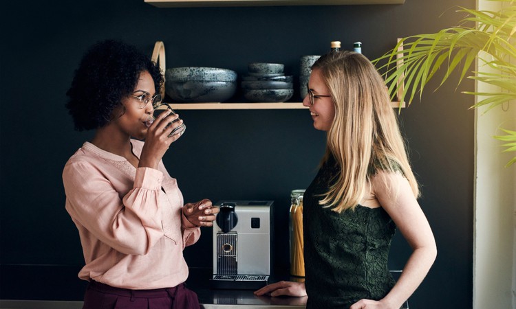 two diverse women standing at coffee machine taking a break at work | In Time for the Holidays: How to Take Breaks Effectively  https://positiveroutines.com/how-to-take-breaks/