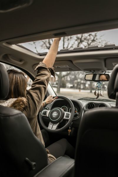 woman driving jeep with hand out of the sunroof | How to Make the Most of Your Commute to Work https://positiveroutines.com/commute-to-work-tips/