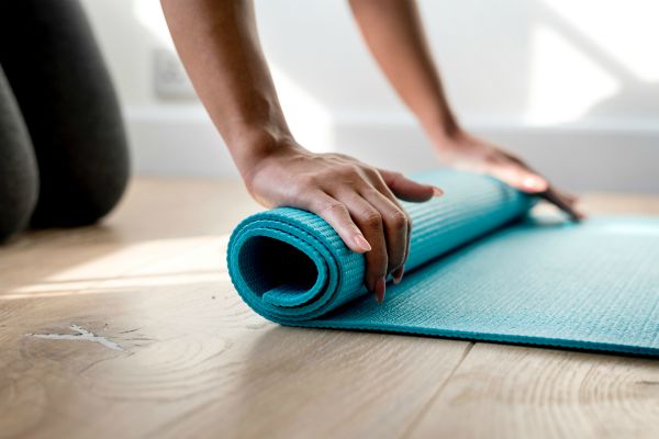 woman rolling up blue yoga mat | In Time for the Holidays: How to Take Breaks Effectively  https://positiveroutines.com/how-to-take-breaks/