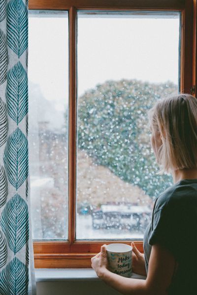 woman holding mug looking out window at snow | [Video] This is the Gratitude Meditation You Need This Fall  https://positiveroutines.com/gratitude-meditation/