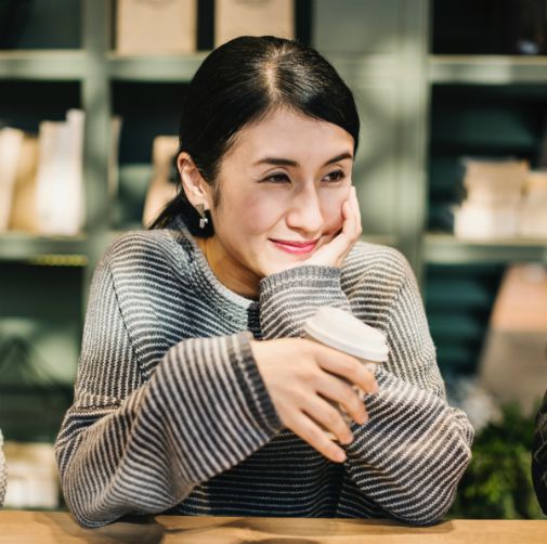 woman smiling drinking coffee while taking a break | 7 Surprising Ways to Be Successful at Work https://positiveroutines.com/successful-at-work/