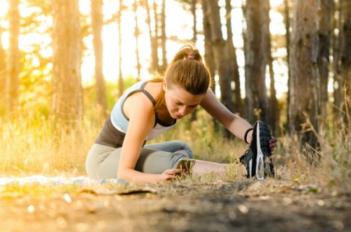 woman stretching outside in forest | 67 Healthy Mind and Body Tips to Last You All Winter https://positiveroutines.com/healthy-mind-and-body-tips/
