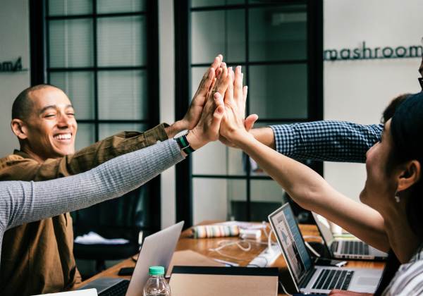 colleagues high fiving at office | The Happiest Stories of 2018 to Get You in The Spirit https://positiveroutines.com/happiest-stories/