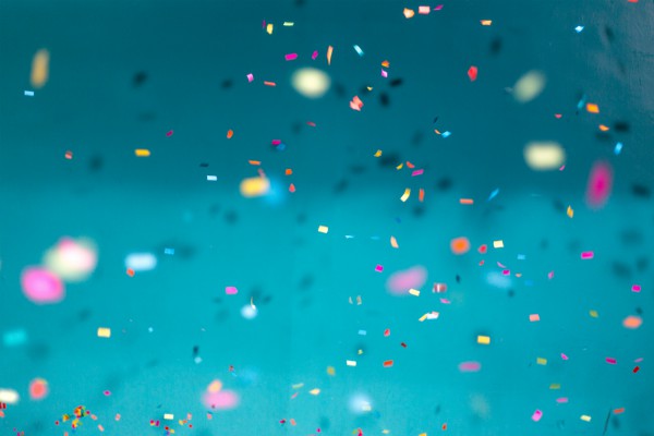 colorful confetti on blue background | The Unmistakable Magic of The 4 Day Week https://positiveroutines.com/four-day-week/