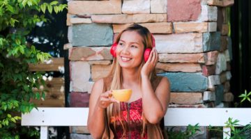 female with red headphones enjoying tea | The Most Inspirational Podcasts of 2018 https://positiveroutines.com/inspirational-podcasts/