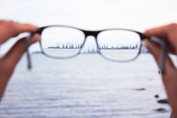 person holding glasses against skyline focus concept | How To Get Focused In The Morning https://positiveroutines.com/get-focused/