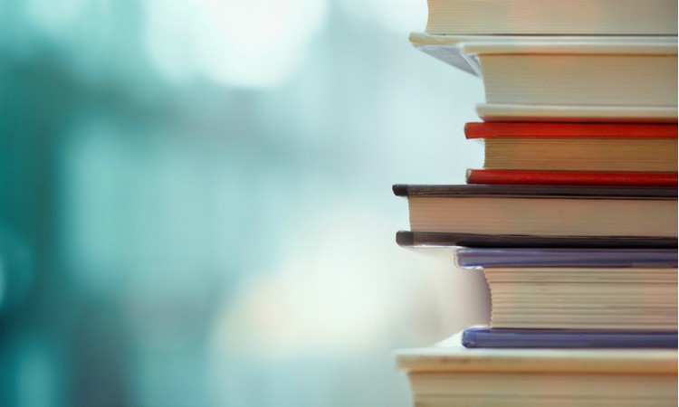 stack of books against blue background | 11 Productive Books To Transform Your New Year https://positiveroutines.com/productive-books/