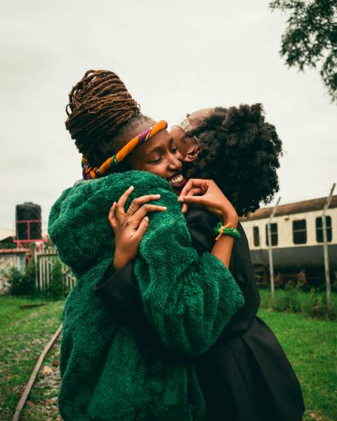 two diverse women hugging outside | The Happiest Stories of 2018 to Get You in The Spirit https://positiveroutines.com/happiest-stories/