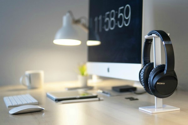 black wireless headphones on work desk | 9 Ways to Improve Focus in a Distracted Environment https://positiveroutines.com/improve-focus/