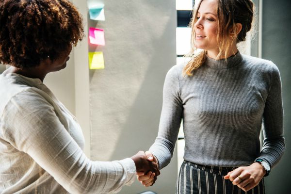 two professional women shaking hands | 11 Productive Things to do With Your Free Time https://positiveroutines.com/productive-things-to-do/