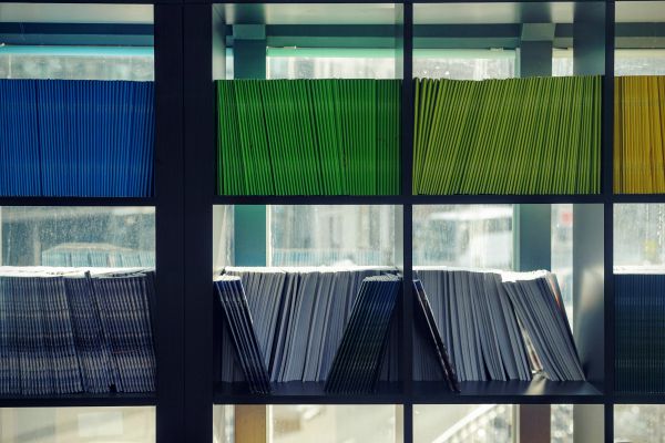 blue and green folders organized on shelving | 11 Things You Need to Have a Productive Day https://positiveroutines.com/have-a-productive-day/