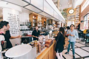 customers at register in busy coffee shop | How to be Selfless This Valentine's Day https://positiveroutines.com/how-to-be-selfless/