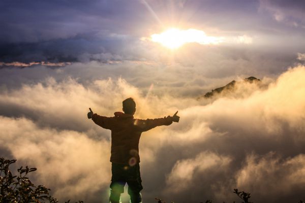 excited male on mountain top with open arms | How to Take Advantage of a Flexible Schedule https://positiveroutines.com/flexible-schedule-tips/