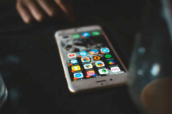iphone on table displaying social media apps | Make These 5 Tiny Tweaks to Have A Great Morning https://positiveroutines.com/great-morning-tips/