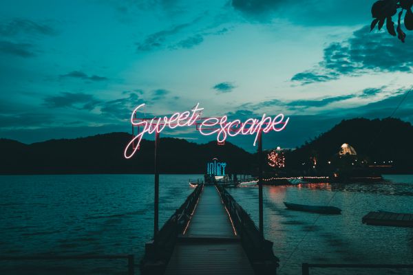 neon sign at end of pier reading sweet escape | How to Take Advantage of a Flexible Schedule https://positiveroutines.com/flexible-schedule-tips/