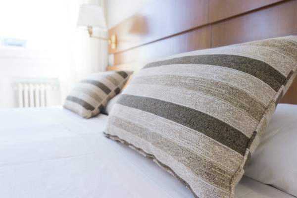 plush brown striped pillows on tidy bed | 11 Things You Need to Have a Productive Day https://positiveroutines.com/have-a-productive-day/
