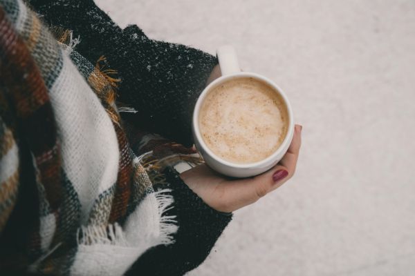 woman holding hot cocoa outdoors with snow on ground | 11 Kind Acts to Brighten Someone's Day https://positiveroutines.com/kind-acts/
