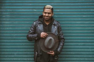 happy confident man holding hat | 13 Gratitude Journal Prompts to Try This International Day of Happiness https://positiveroutines.com/gratitude-journal-prompts/