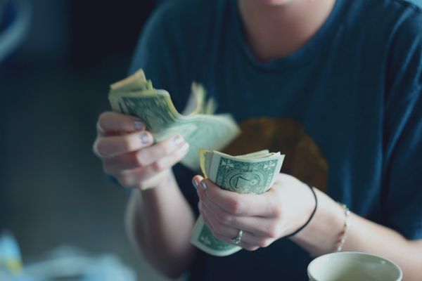 person counting US dollar bills | The Best Free Budgeting Apps to Hit Your Goals  https://positiveroutines.com/free-budgeting-apps/