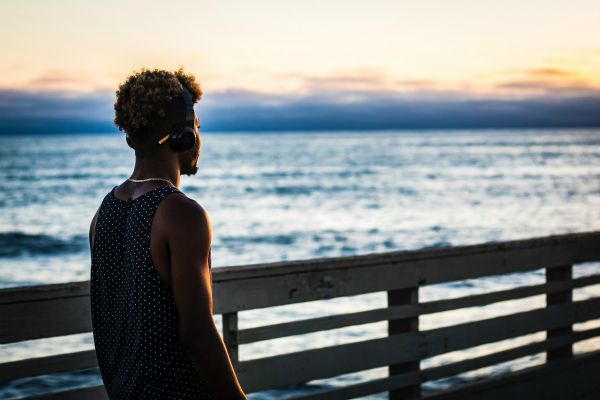 young man walking on pier overlooking ocean | 6 Surprising Things to Add To Your Everyday Routine https://positiveroutines.com/everyday-routine-hacks/